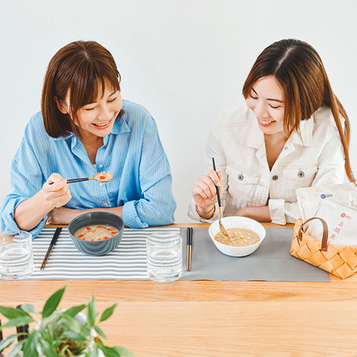 Two ladies eating porridge happily